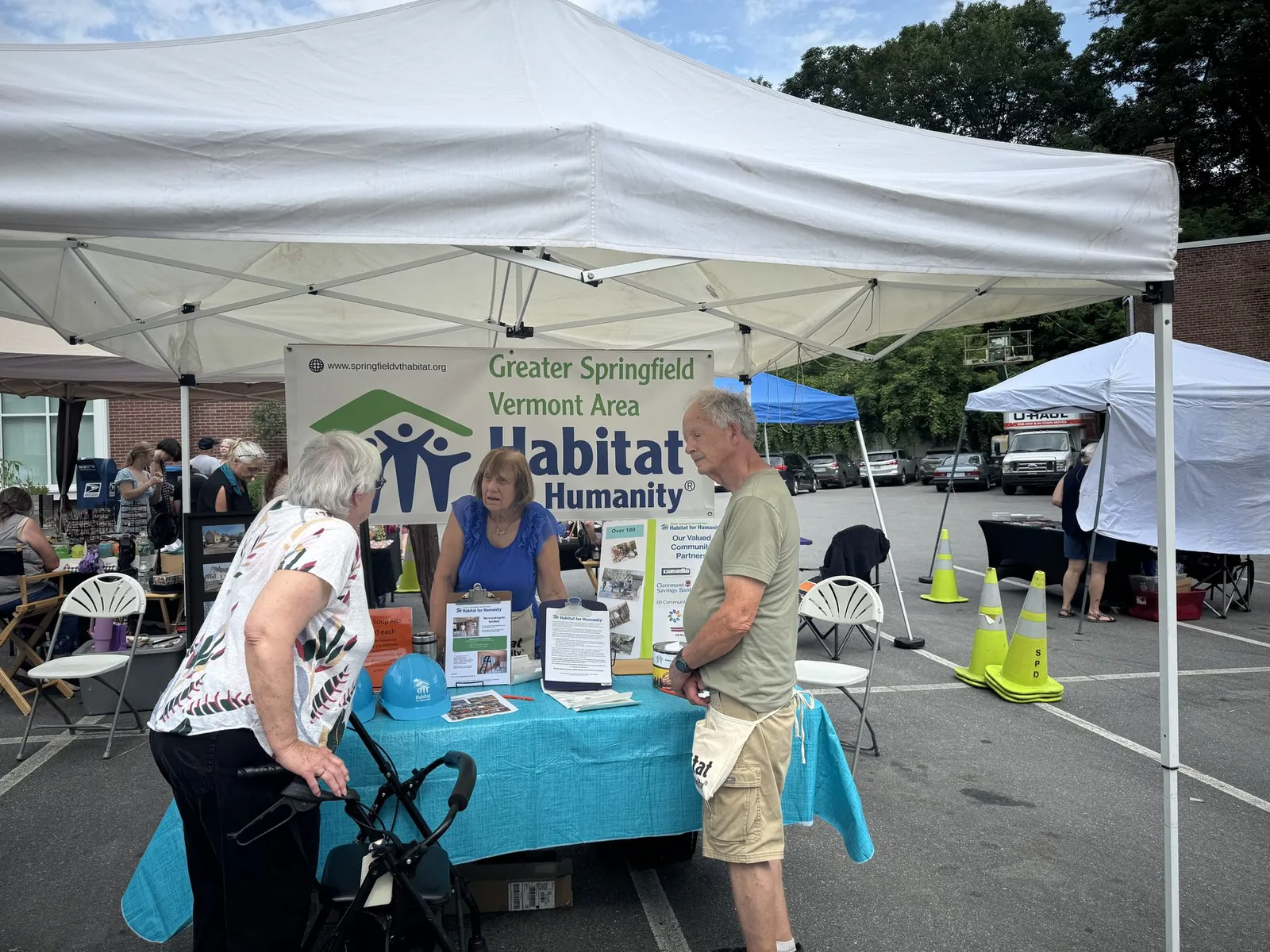 Volunteers at the Habitat booth talking with visitors at the Springfield Street Fest